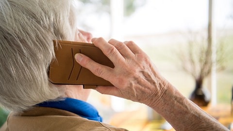 Eine Seniorin telefoniert mit ihrem Smartphone.