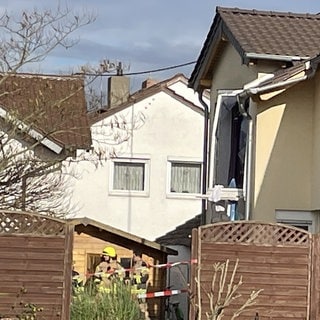 Das Einfamilienhaus von der Seite, der Fensterrahmen hängt heraus: In dem Wohnhaus in Worms kam es zu einer Explosion