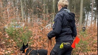 Eine Polizisten sucht mit einem Hund nach sterblichen Überresten von Melanie Frank. Das 13-jährige Mädchen war 1999 in Wiesbaden verschwunden.