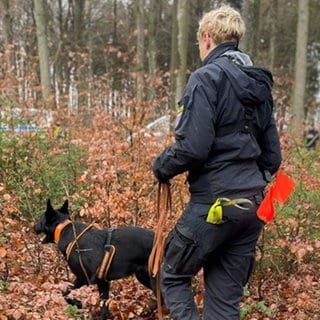 Eine Polizisten sucht mit einem Hund nach sterblichen Überresten von Melanie Frank. Das 13-jährige Mädchen war 1999 in Wiesbaden verschwunden.