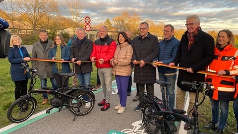 Verkehrsministerin Schmitt schneidet am Pendel-Radweg Mainz-Bingen ein rotes Band durch. 