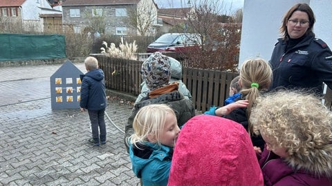 Ein Junge löscht die Flammen-Attrappen an einem Haus im Hof der Feuerwehr Wörrstadt-Rommersheim.