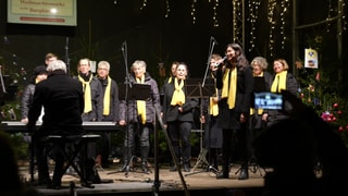 Auf dem Weihnachtsmarkt in Ingelheim an der Burgkirche singt ein Gospelchor