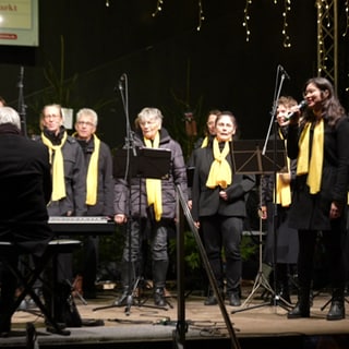 Auf dem Weihnachtsmarkt in Ingelheim an der Burgkirche singt ein Gospelchor