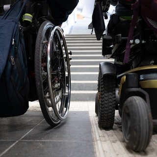 Symbolbild: Zwei Rollstuhlfahrer vor einer Treppe. Die Kreuznacher Diakonie hat in einer ihrer Einrichtungen für Menschen mit Behinderungen falsch abgerechnet. 