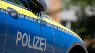 Ein Polizeiauto steht vor einem Haus.