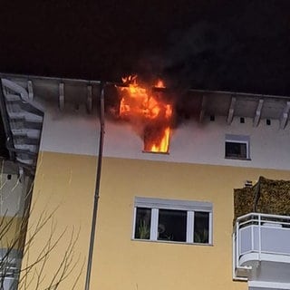 Flammen schlagen in der Silvesternacht aus dem obersten Stock eines Wohnhauses in Wiesbaden.