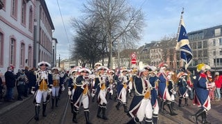 Gardisten ziehen beim Neujahrsumzug der Garden in Mainz am Schillerplatz vorbei.