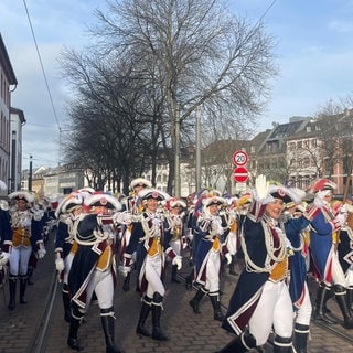 Gardisten ziehen beim Neujahrsumzug der Garden in Mainz am Schillerplatz vorbei.