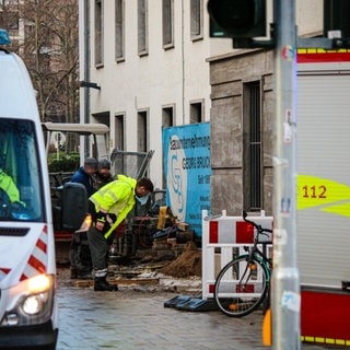 Mitarbeiter der Mainzer Netze untersuchen die Stelle, an der die Schillerstraße in Mainz durch einen Wasserrohrbruch unterspült wurde.