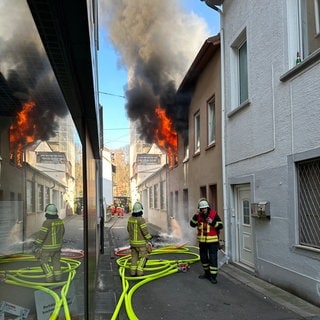 Zwei Feuerwehrleute vor einem brennenden Haus in der Bad Kreuznacher Innenstadt.