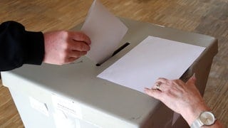 Eine Frau wirft einen Wahlschein in eine Urne: im Kreis Mainz-Bingen findet am 23. Februar die Landratswahl statt