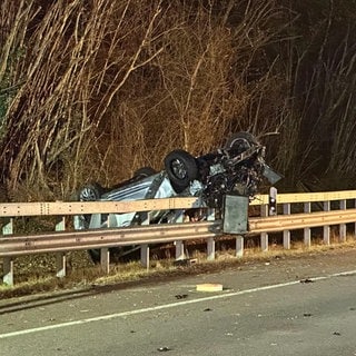 Das Auto hat sich überschlagen und liegt hinter der Leitplanke der A643 auf Höhe des Autobahndreiecks Mainz. Ein Mensch kam ums Leben. 