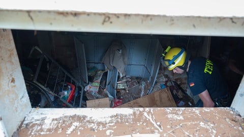 Ein THW-Helfer arbeitet in einem vom Hochwasser betroffenen Keller.  