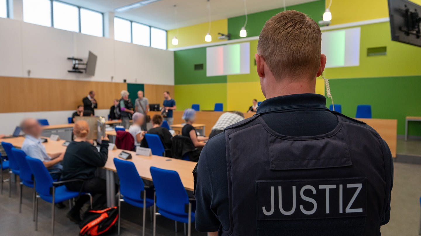 Angeklagte Klimaaktivisten sitzen mit ihren Anwälten in einem Gerichtssaal des Amtsgerichts Trier.