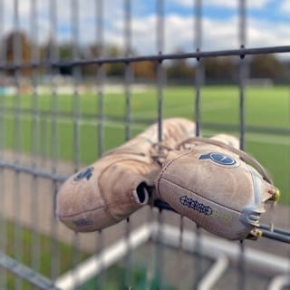 Fußballschuhe hängen am Zaun im Moselstadion in Trier