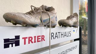 Fußballschuhe auf dem Eingangsschild am Rathaus Trier