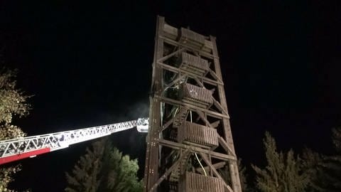 Der Aussichtsturm am Idarkopf qualmt, ein Feuerwehrkran ist am Löschen.