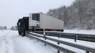 Ein Lkw ist auf schneeglatter Fahrbahn in die Leitplanken gefahren