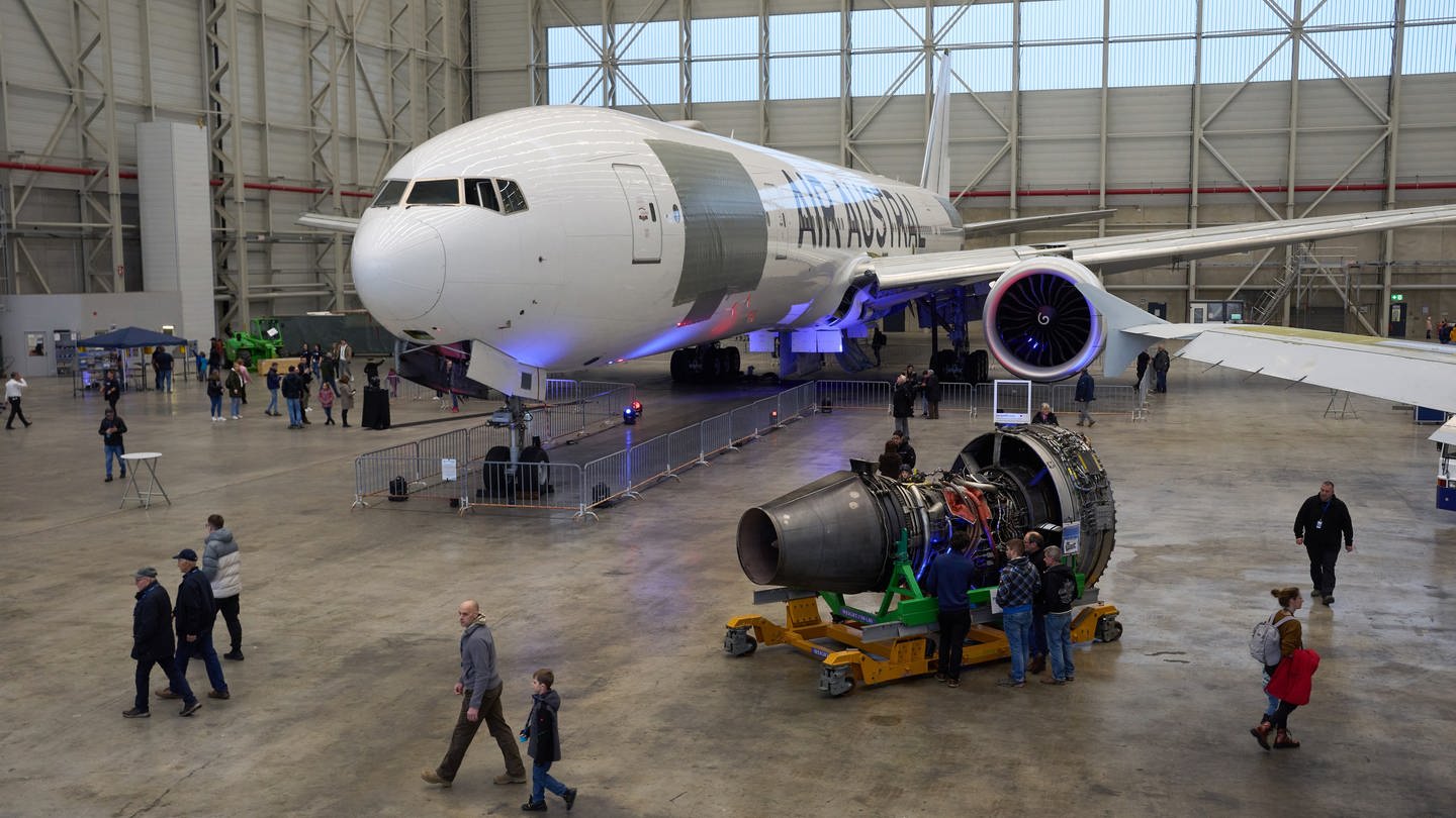 Besucher betrachten ein Flugzeug in einem Hangar des Flughafens Hahn.