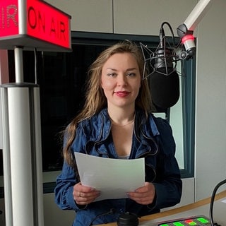 Anna-Carina Blessmann am Mikrofon im Nachrichtenstudio des Studios Trier.