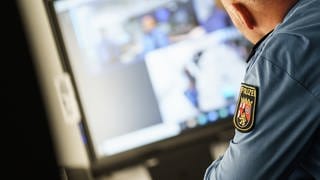 Ein Polizeibeamter sitzt in der Führungszentrale des Polizeipräsidiums Mainz an seinem Arbeitsplatz.