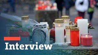 Bildmontage: Schriftzug Interview mit Kerzen auf einem Steinpoller vor der Porta Nigra in Trier am Tag nach der Amokfahrt