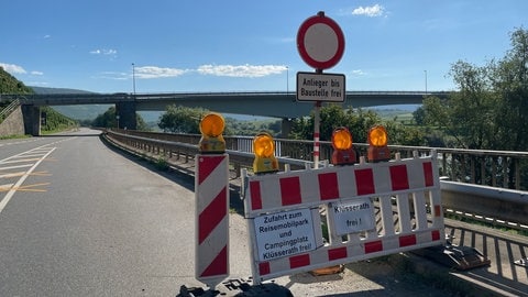 Eine Absperrung auf der Bundestraße 53 in Richtung Klüsserath. Angebrachte Schilder der Bewohner sollen Touristen darauf hinweisen, dass sie in den Ort fahren können. Viele Gäste schreckt die Baustellenabsperrung trotzdem ab. 