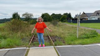 Andrea Horst kann gefahrlos auf den Zuggleisen stehen, denn durch Höchstberg in der Eifel ist schon seit über zehn Jahren kein Zug mehr gefahren.