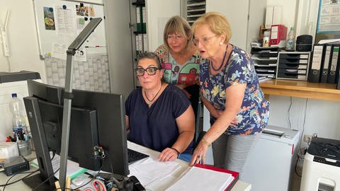 Tierschutzverein-Mitarbeiterinnen bearbeiten Akten vor dem Bildschirm