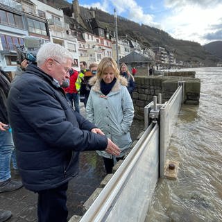 Zells Stadtbürgermeister Hans-Peter Döpgen (FWG) zeigt Umweltministerin Kartin Eder (Die Grünen), wie die Hochwasserlage vor Ort ist.