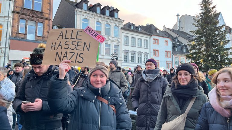 Die Menschen sind zur Demo in Trier mit Plakaten und Slogans unterwegs. 