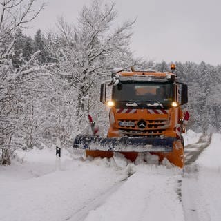 Nach einem Wintereinbruch ist ein Schneepflug in der Eifel unterwegs. Der Deutsche Wetterdienst warnt, dass es weiterhin glatt sein kann. 