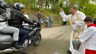 Pater Albert segnet Motorradfahrer in Klausen.