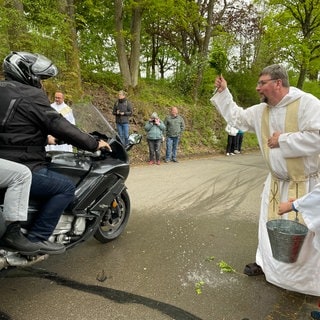 Pater Albert segnet Motorradfahrer in Klausen.