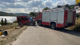 Das in der Mosel versunkene Feuerwehrauto wird mit einer Seilwinde aus dem Fluss geborgen und an Land gezogen