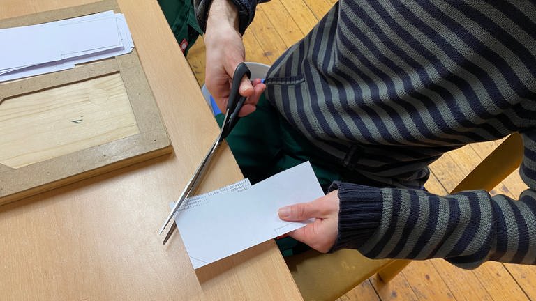 Im ersten Schritt scheidet Matthias die Tüten für die Bohnen zu. Das Papier kommt von Fehldrucken einer Firma, die es kostenlos zur Verfügung stellt.