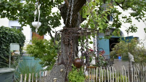 Alte Schlüssel hängen an einem Kuchenrost unter dem Pfirsischbaum. Die Konder-Michelots sammeln gerne alte Dinge, um sie im Garten auszustellen.
