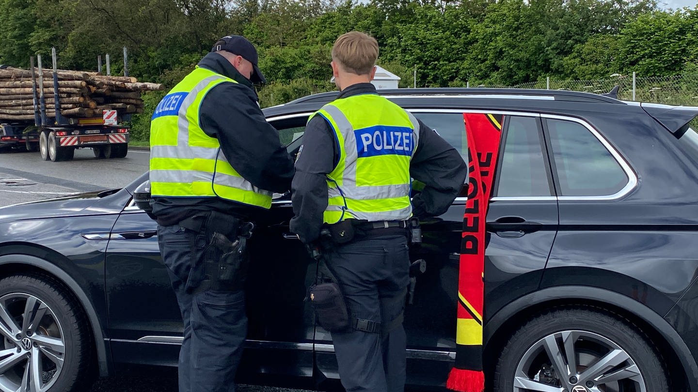 Bundespolizisten kontrollieren Autos, die aus Belgien nach Deutschland fahren. Heute sind auch viele Fußballfans dabei.