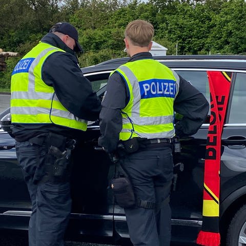 Bundespolizisten kontrollieren Autos, die aus Belgien nach Deutschland fahren. Heute sind auch viele Fußballfans dabei.