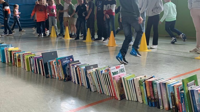 Die Kinder in der Grundschule Nittel haben viele Meter Bücher aufgestellt, um zu messen, wie viele Meter sie gelesen haben.