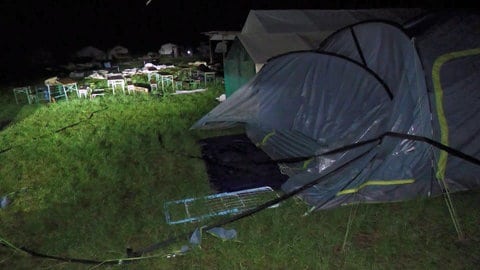 Ein vom Gewitter zerstörtes Zelt auf einer Wiese: Das Unwetter hat in einem Zeltlager in Schladt Schäden angerichtet.