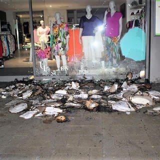 Spuren des Brandes vor einem Geschäft in der Trierer Innenstadt. Fast zeitgleich wurde ein weitere Brand gemeldet. Die Polizei Trier ermittelt. 