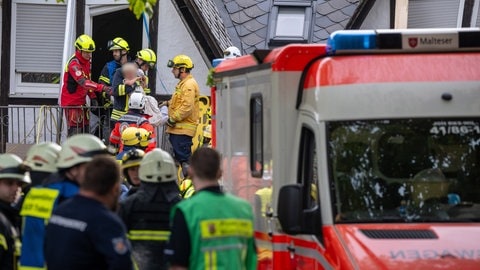 Ein Kind wird von Rettungskräften aus dem teilweise eingestürzten Hotel in Kröv gerettet. 