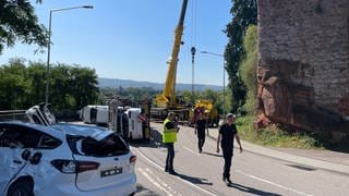 Ein Kran richtet den umgekippten Autotransporter auf der B51 bei Trier wieder auf. Die "Bitburger" bleibt zunächst gesperrt.