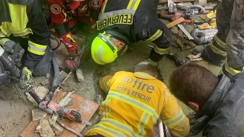 Feuerwehrleute gelangen über einen engen Schacht zu Verschütteten in einer Hotelruine in Kröv