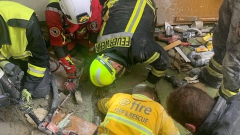 Feuerwehrleute gelangen über einen engen Schacht zu Verschütteten in einer Hotelruine in Kröv