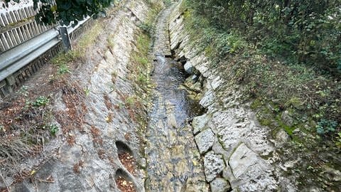 Der Steintrog, durch den die Riveris fließt, wurde beim Hochwasser beschädigt. Beim nächsten Hochwasser könnten weitere Steine rausbrechen und die Brückendurchflüsse verstopfen. Dann würde das Wasser wieder über die Straße laufen. 