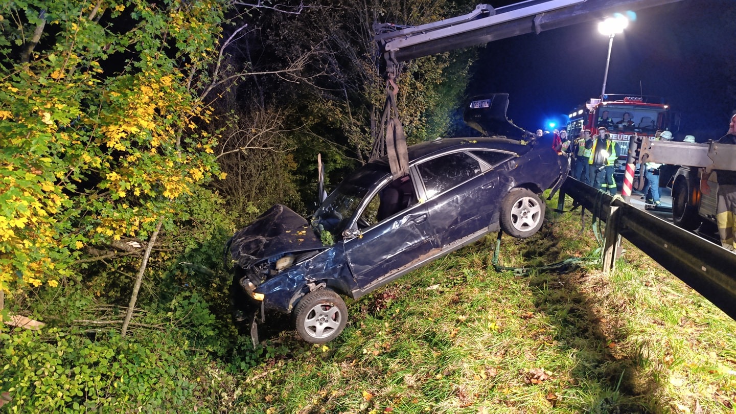 Ein Auto wird nach einem schweren Unfall geborgen. Der Fahrer war eine Böschung hinabrgestürzt und senkrecht zum Liegen gekommen.