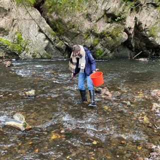 Geologin Sabine Kummer steht mit Gummistiefeln in der Lieser bei Manderscheid in der Eifel. Sie sucht nach Saphiren. In der Eifel gibt es nämlich Edelsteine. 